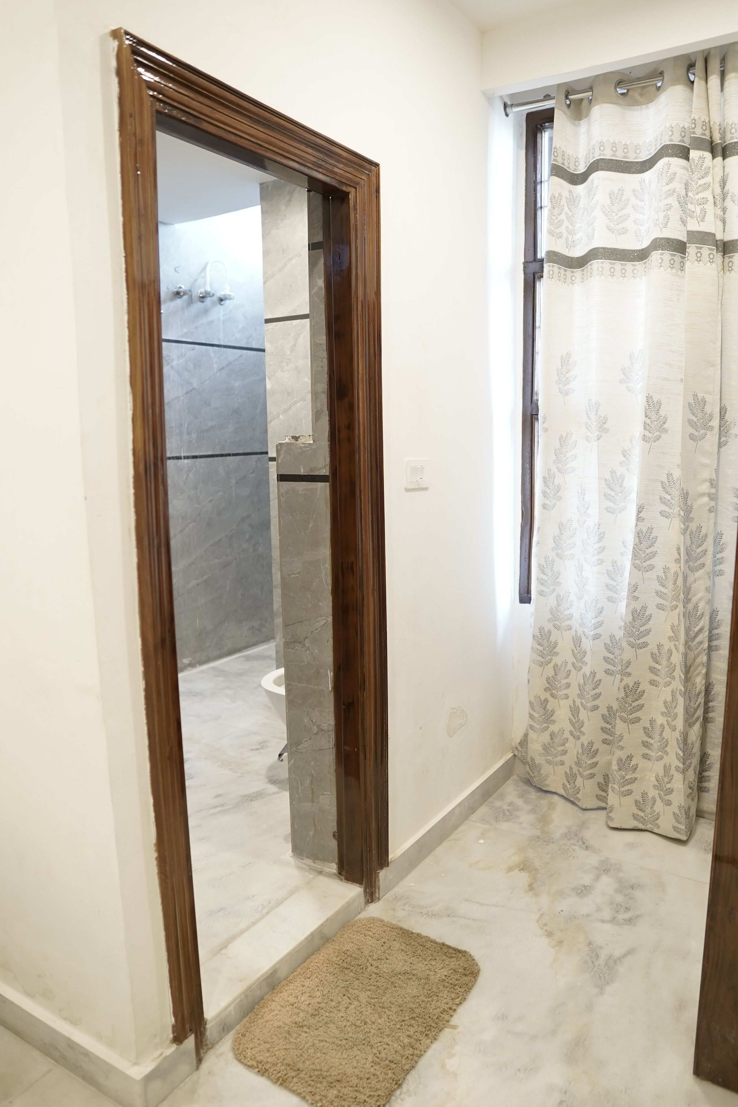 A bathroom with a shower, a mirror, and a curtain.