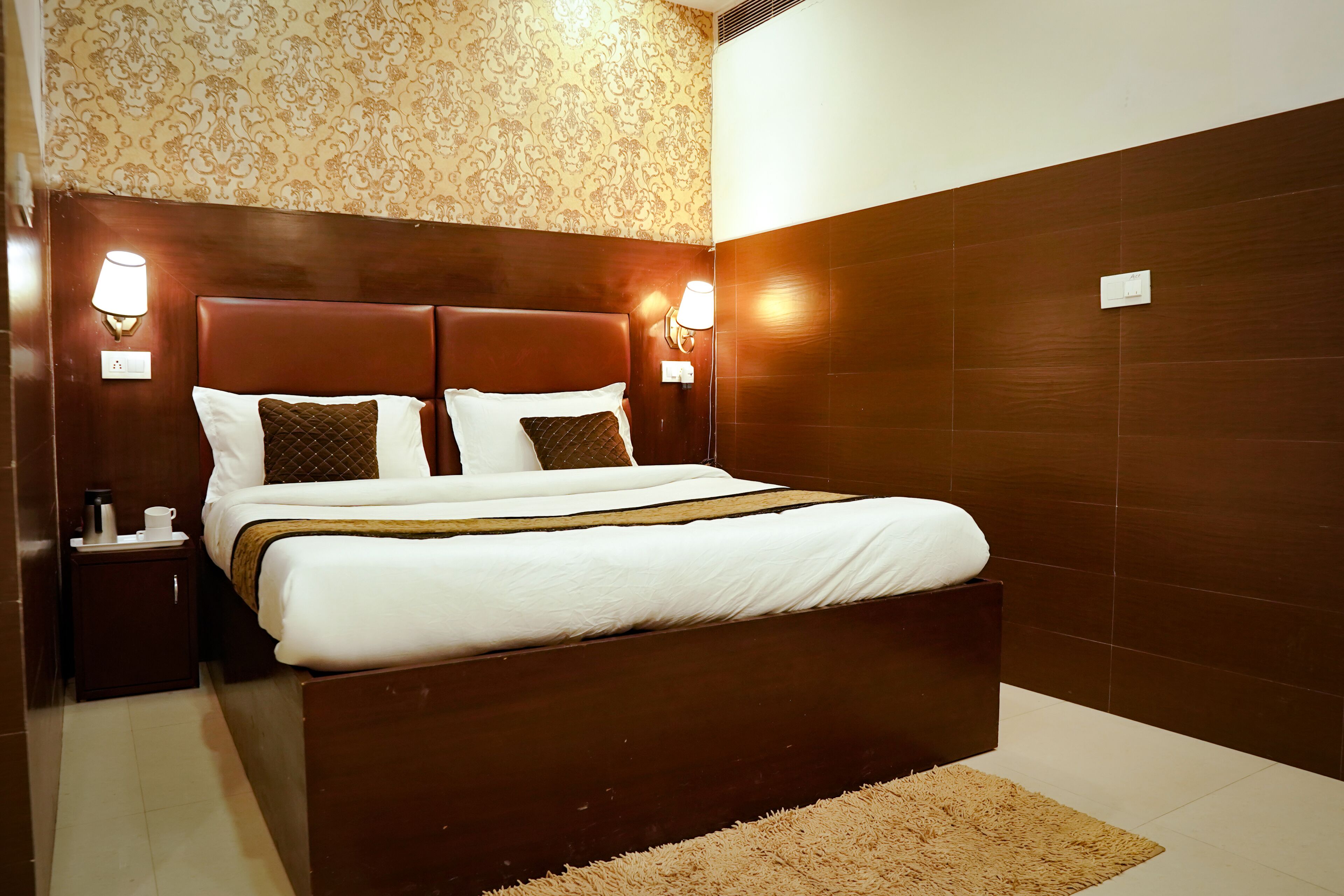 Un dormitorio moderno con una cama grande, dos mesitas de noche y lámparas de pared.