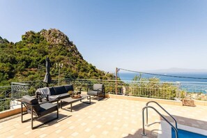 A terrace with outdoor seating and a pool, overlooking a mountainous landscape. - Aigli Luxury Villa - Panoramic Seaview Retreat (Kalamata)