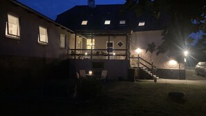 Ein Haus mit überdachter Veranda, einer Treppe und einem geparkten Auto davor.