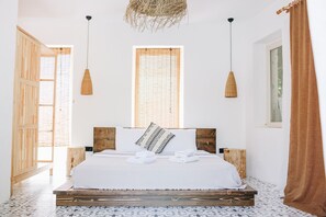 A bedroom with a large bed, wooden headboard, two hanging lamps, a window with bamboo blinds, and a woven ceiling decoration. - Dud Otel Alaçatı (Cesme)