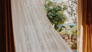 A room with a sliding glass door, a patterned floor, and a view of greenery outside. - Dud Otel Alaçatı (Cesme)