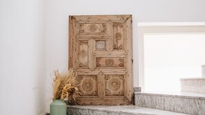 A set of marble stairs leading up to a wooden door with intricate carvings. - Dud Otel Alaçatı (Cesme)