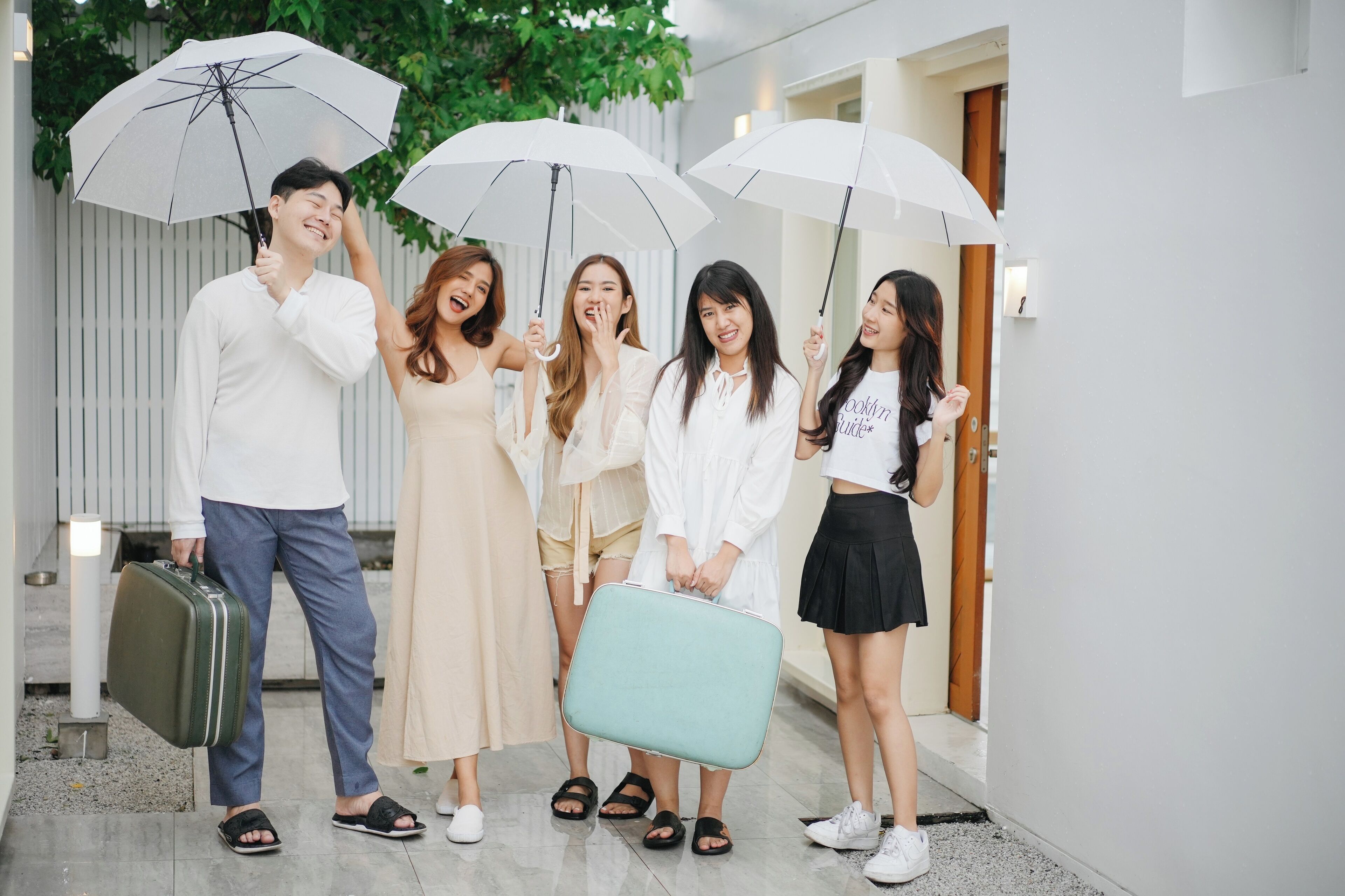 A group of people standing in a hallway with white walls and a wooden door.
