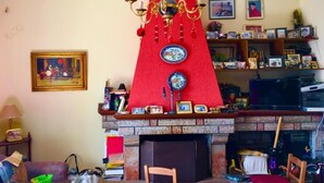 Ein Wohnzimmer mit Kamin, einer Kristallleuchter und einer Bücherwand mit Büchern und Dekoration.