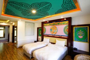A hotel room with two beds, a decorative ceiling, and traditional wall art. - The Shanti Nest At Boutique Hotel (Leh)