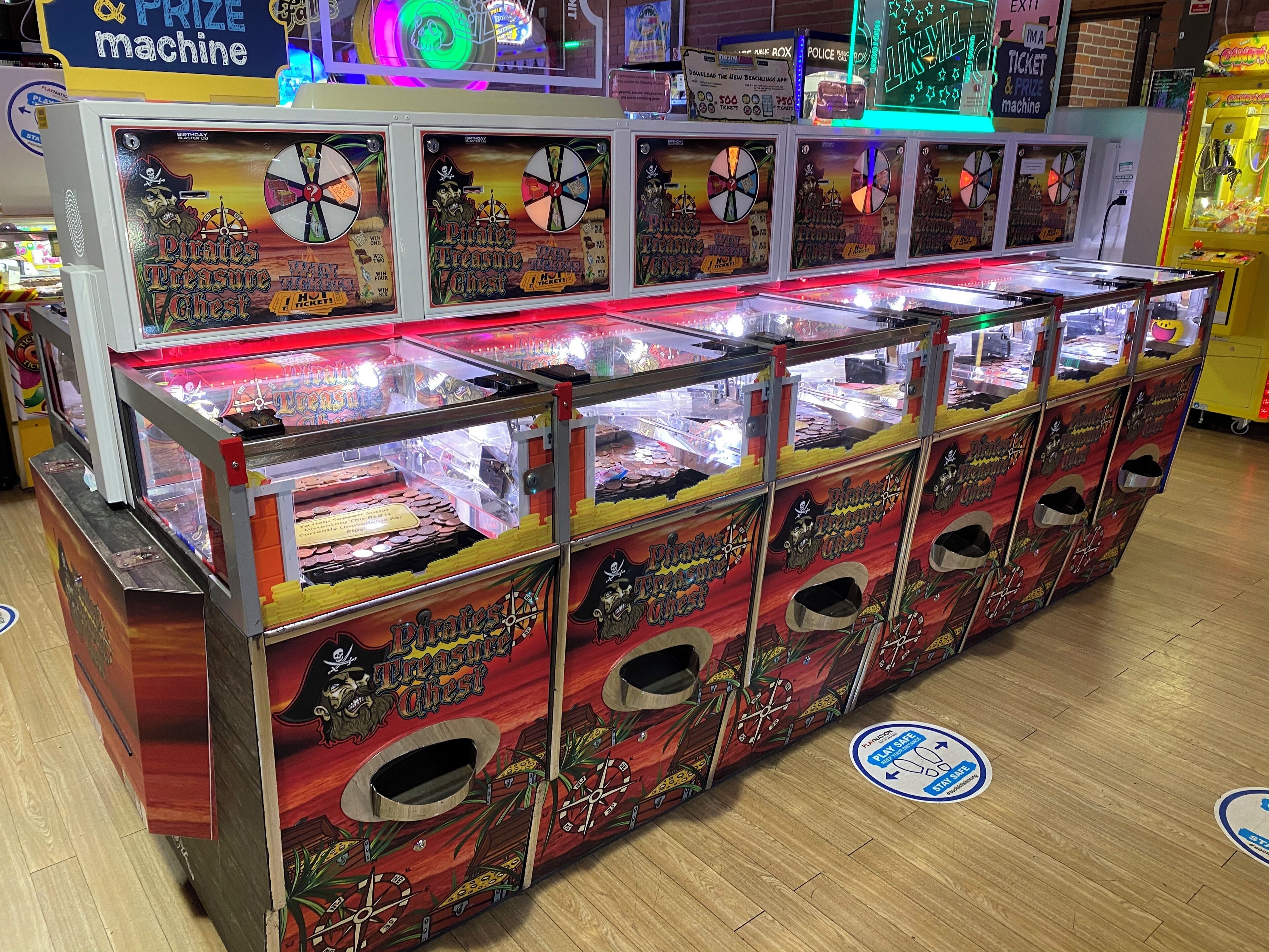 A row of arcade machines with pirate-themed designs, including 'Pirates Treasure Chest' and 'Pirates Treasure Chest II'.