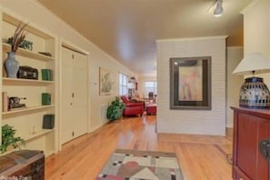 Stylish hallway leads to a cozy living area with a sofa and artwork.