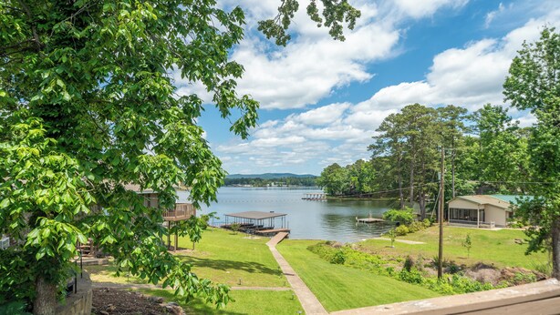 A lakeside property with a dock, a covered seating area, and a well-maintained lawn. - Spectacular House on Lake Hamilton (Lake Hamilton)
