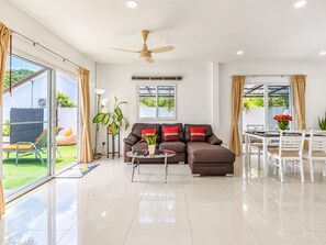 A modern living room with a sofa, coffee table, and dining area. - Star villa 2 bedrooms /Private swimming pool for family (Tambon Chalong)