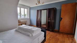 A bedroom with a bed, a wardrobe, and a window. - Beautiful renovated house in Lambell - 5min from beaches and Tregunc center (Trégunc)