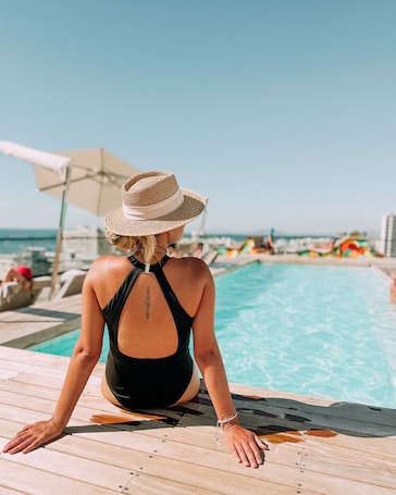 Una piscina al aire libre, sillones reclinables de piscina