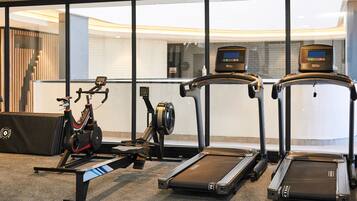A gym with stationary bikes, treadmills, and a rowing machine.