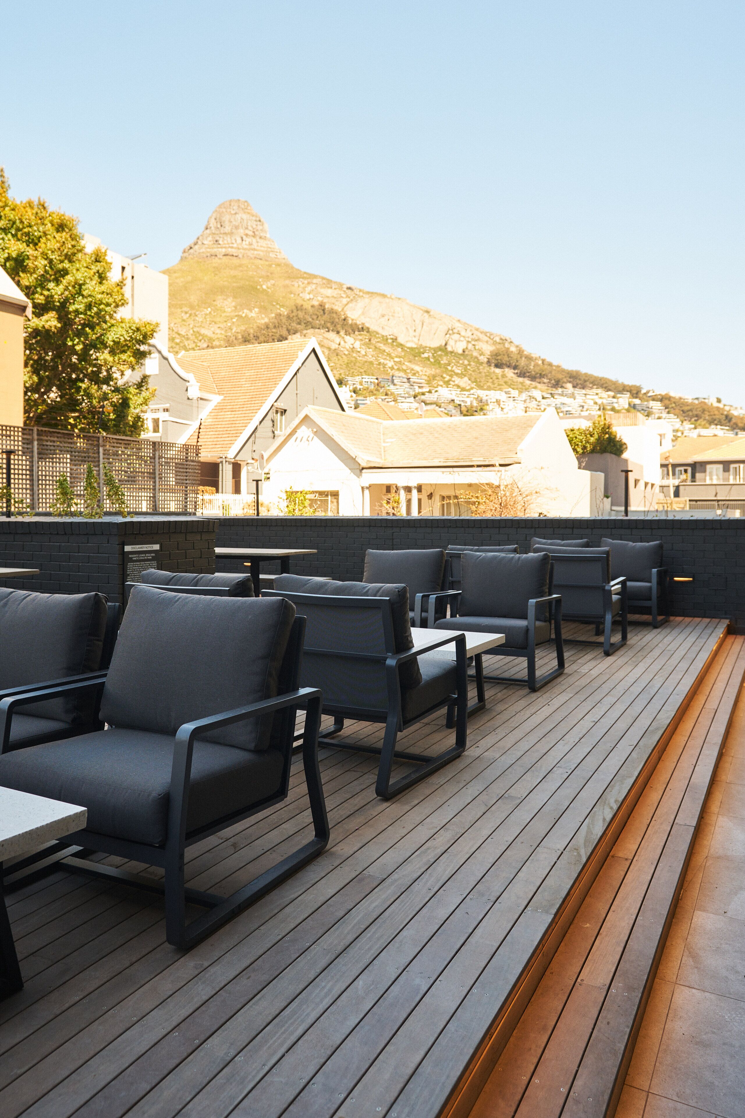 A deck with outdoor seating and a view of a mountain.
