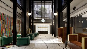 A spacious lobby with a high ceiling, a large clock, and seating areas. - Home Suite Hotels Station House (Cape Town)