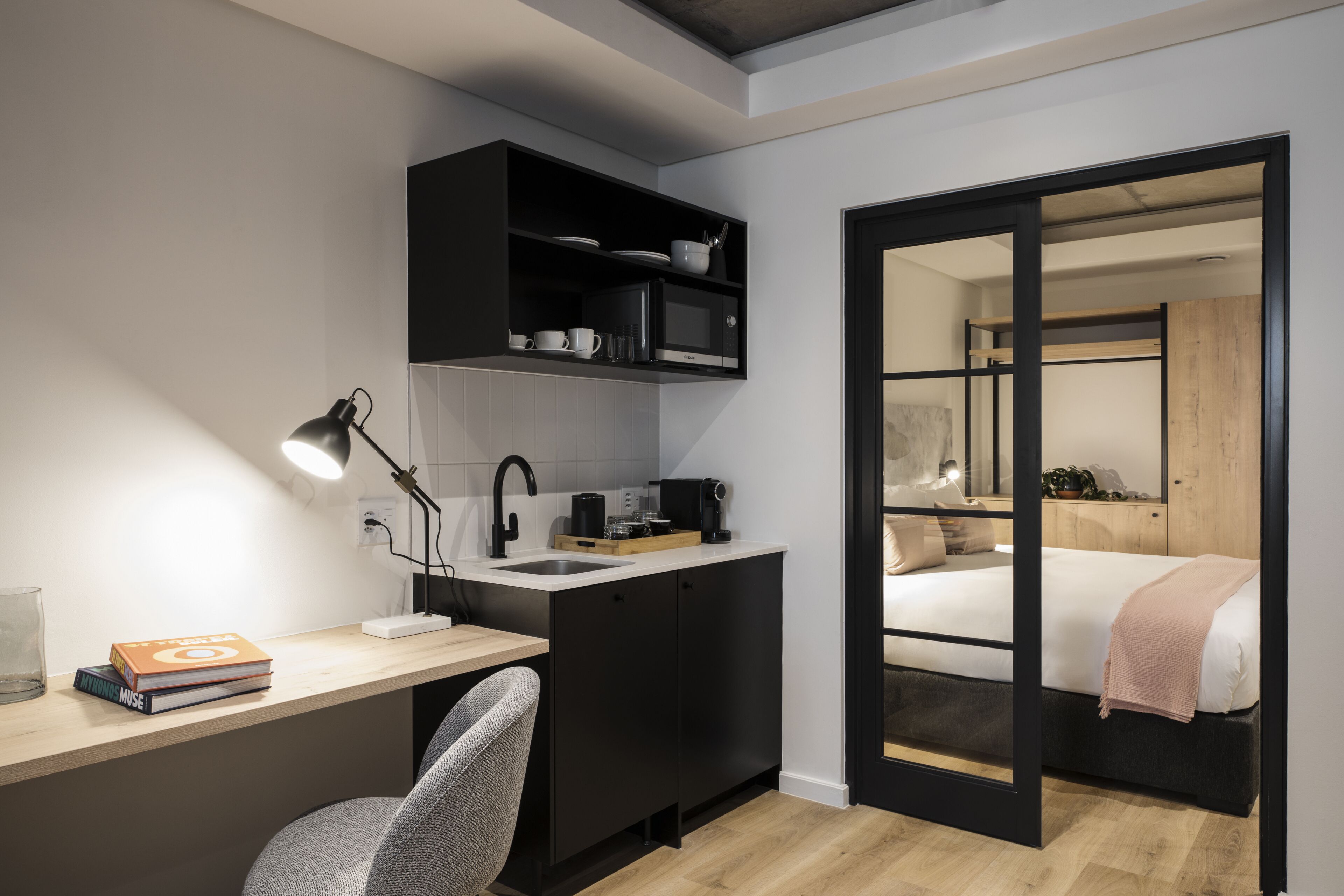 Een kleine slaapkamer met een bed, een nachtkastje en een bedtafel.