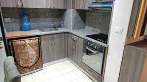 Enjoy cooking in this kitchen with an oven, sink, and small refrigerator.