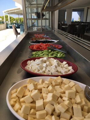 A buffet with various food options including fruits, vegetables, and tofu. - ŞAFAK OTEL (Didim)