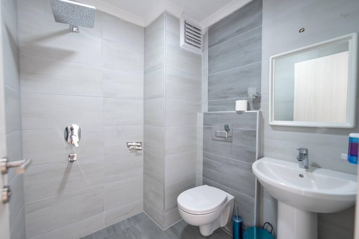 Un baño moderno con ducha, inodoro y lavabo.