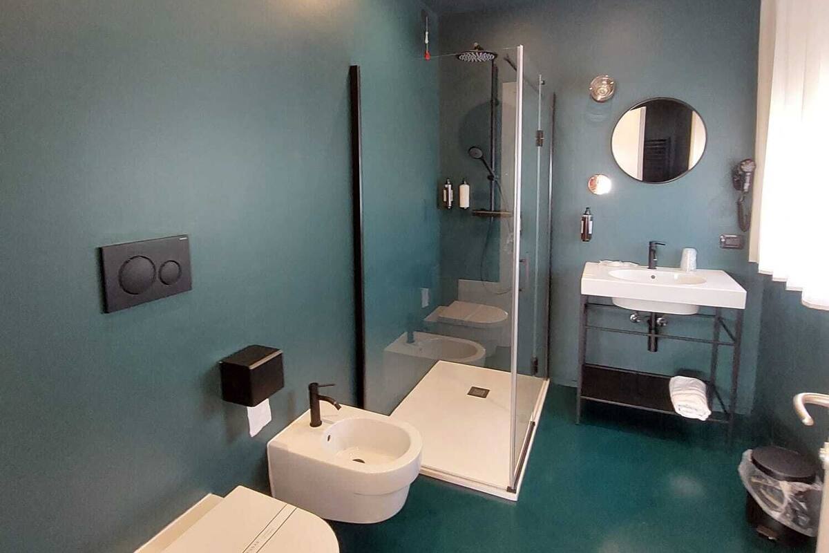 A modern bathroom with a shower, two sinks, and a toilet.