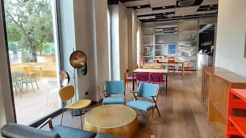 Un interno moderno con zone salotto, ampie finestre e una cucina sullo sfondo.