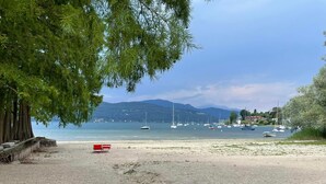 A beach with boats, a clear sky, and mountains in the background. - The Gulf Sailor's Cottage - Lake Maggiore (Cantone)