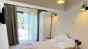 A bedroom with a bed, bedside tables, a wardrobe, and a view of the outdoors. - Serez Otel Alaçatı by La Mira (Cesme)