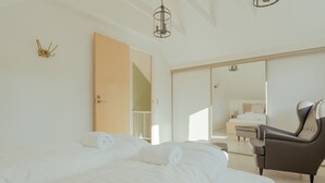 A hotel room with a bed, a chair, a wardrobe, and a mirror. - Large Penthouse Apt - Downtown - Marina (Tórshavn)