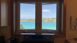 Une cuisine dotée d’une double fenêtre donnant sur une vue sur la côte.