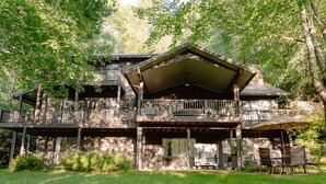 A two-story wooden cabin with a covered porch and multiple balconies.
