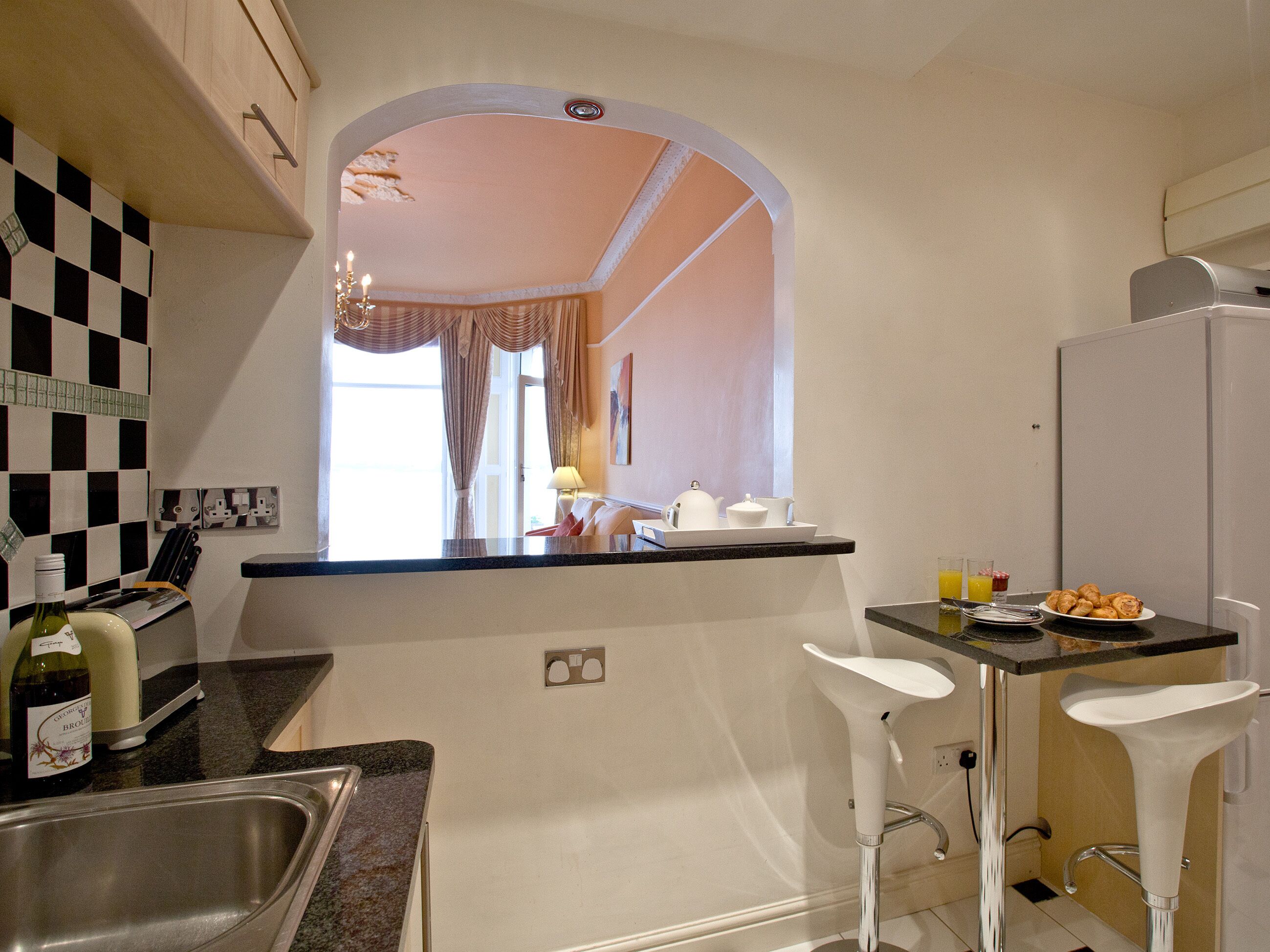 A compact kitchen with a central island, a sink, and a breakfast bar.