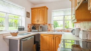 A kitchen with wooden cabinets, a dishwasher, a microwave, and a toaster.