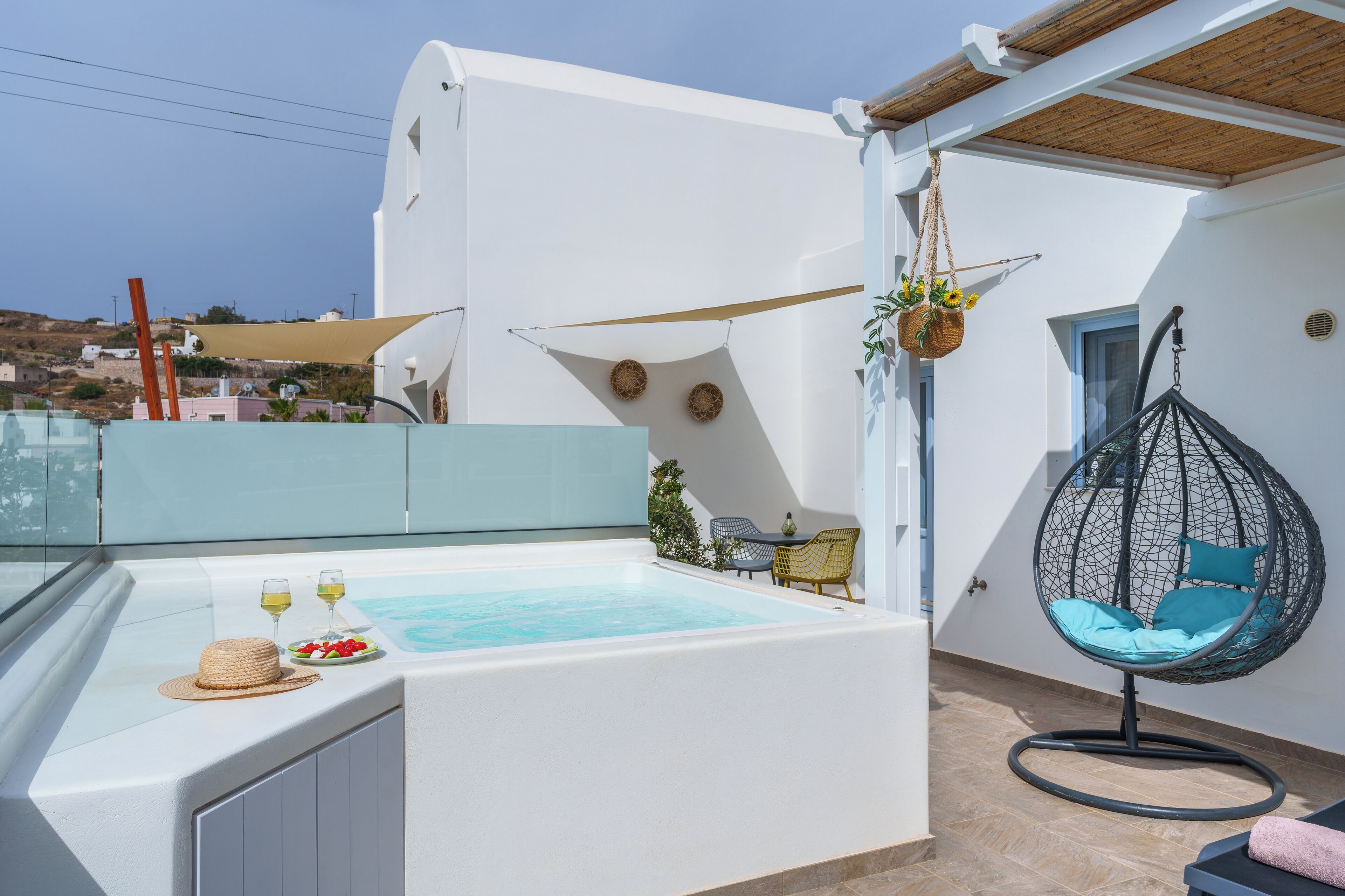 Terraço no telhado com hidromassagem, área de estar e cadeira suspensa.