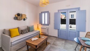 Una sala moderna con sofá, una mesa de centro y un comedor con sillas azules.