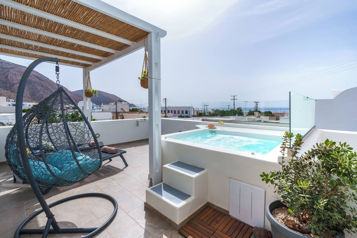 Um terraço no telhado com hidromassagem, uma cadeira suspensa e um vaso de planta.