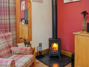 A cozy room with a fireplace, plaid furniture, and a mirror.