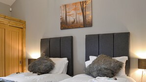 Ein Schlafzimmer mit zwei Betten, einem Holzschrank und einem Bild an der Wand.