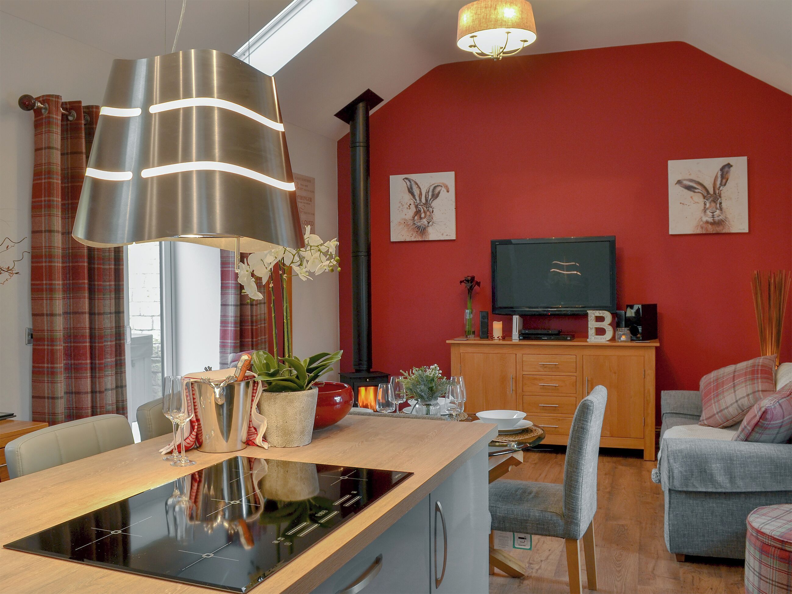 Un salon moderne avec un îlot de cuisine, une table à manger, un canapé et un téléviseur.