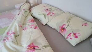A bed with a floral bedspread and matching pillows.