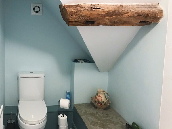 A small bathroom with a toilet, a sink, and a shelf with a pitcher and bowl. - Jasmine Cottage - UK4176 (Middle Mayfield, near Ashbourne)