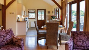 A dining area with wicker chairs, a table, and a view of the outdoors.