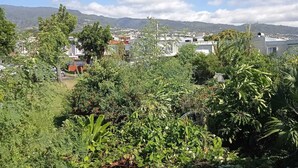 A lush green landscape with a view of a town and mountains in the distance. - Seasonal Rental, Duplex (Saint-Denis)