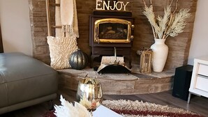 Una sala de estar acogedora con chimenea, un sofá y una mesa de centro de madera con objetos decorativos.
