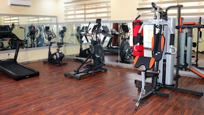 A gym with exercise equipment, a treadmill, and a mirror. - City Green Hotel Yola (Jimeta)