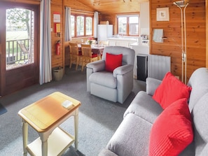 A cozy cabin interior with a dining area, kitchenette, and seating area.
