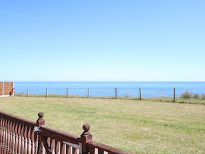 A fenced grassy area with a wooden fence and a mailbox. - 121 (Lowestoft)