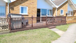 A row of two-story houses with brick exteriors and white trim, featuring front porches and a metal fence. - 121 (Lowestoft)