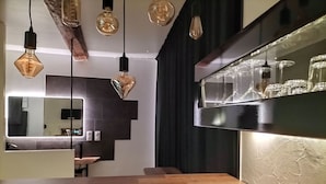 A modern kitchen with a wooden countertop, hanging light fixtures, and a built-in wine rack. - L'essens Fayence... Suite Avec vue Imprenable (Fayence)