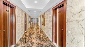 A hallway with marble floors and wooden doors, numbered 201 and 209. - Itsy Hotels Royal Residency (Mohali)