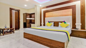 Une chambre d’hôtel avec un grand lit, une tête de lit en bois et une table de chevet.